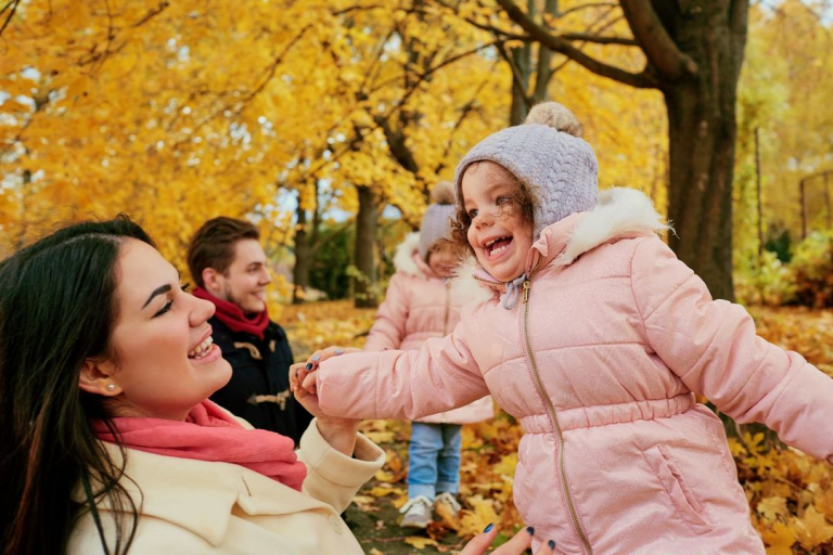 Happy family playing in the autumn in the park.