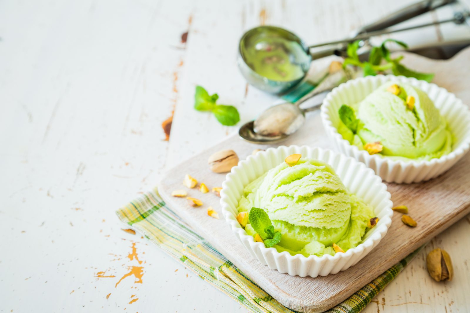 Pistachio ice cream in white bowl, copy space